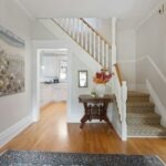 a hallway with a wooden floor and a painting on the wall