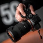 person holding black Sony DSLR camera