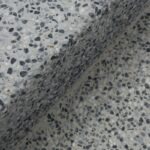 Close-up of a speckled terrazzo surface with a shadow