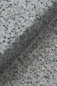 Close-up of a speckled terrazzo surface with a shadow