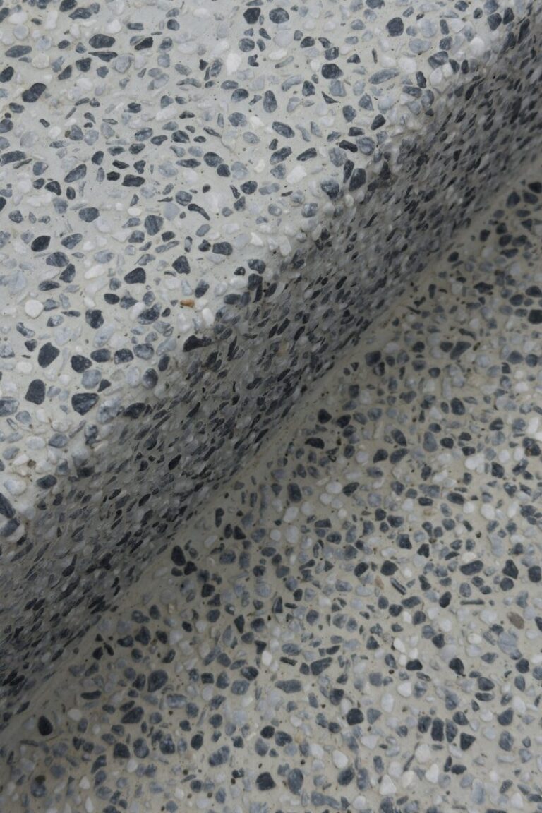 Close-up of a speckled terrazzo surface with a shadow