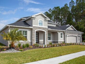 Beautiful modern suburban house in Odessa, FL with lush garden and clear blue sky. {{brizy_dc_image_alt entityId=