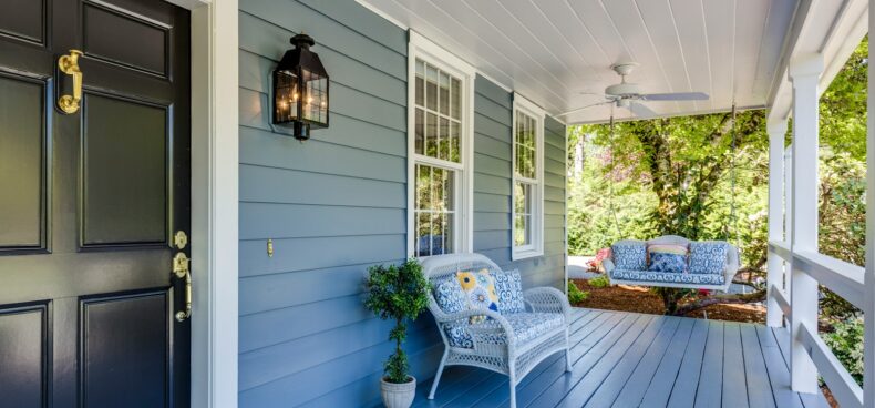 a porch with two chairs and a table on it